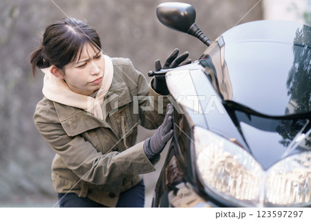 バイクの車体をチェックする女性 バイクの車体をチェックする女性 123597297