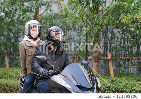 バイクに二人乗りするカップル バイクに二人乗りするカップル 123598106