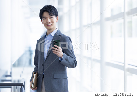 ビジネス スマホを持っている若い男性 ビジネス スマホを持っている若い男性 123598116