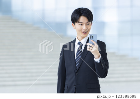 ビジネス　スーツを着てスマホを見ている若い男性 123598699