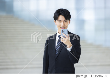 ビジネス　スーツを着てスマホを見ている若い男性 123598700