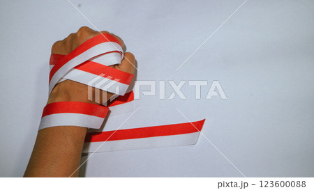 Hand holding red white flag ribbon, celebrate Indonesia independent day on 17 August with isolated background Hand holding red white flag ribbon, celebrate Indonesia independent day on 17 August with isolated background 123600088