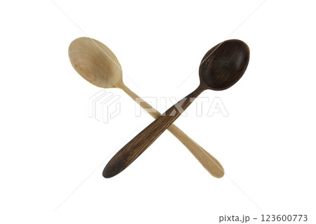 A light and dark wooden spoon are crossed on a white surface, ideal for culinary themes. 123600773