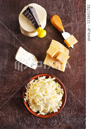 Shredded mozzarella and red cheddar cheese on cutting board Shredded mozzarella and red cheddar cheese on cutting board 123601782