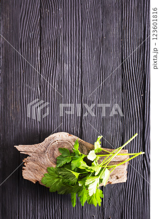 Bunch of the twigs of fresh parsley on a wooden cutting board Bunch of the twigs of fresh parsley on a wooden cutting board 123601816