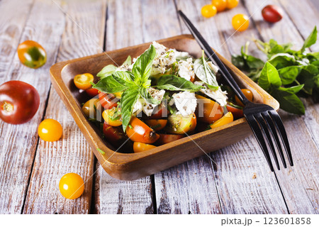 Greek salad with feta cheese and olives on wooden plate Greek salad with feta cheese and olives on wooden plate 123601858