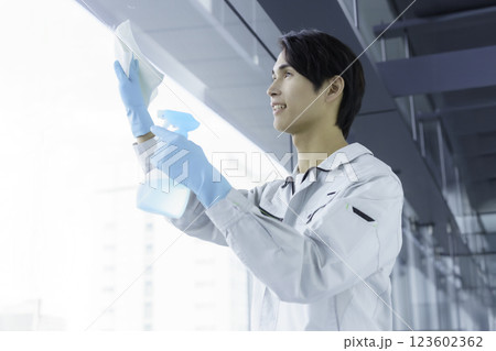 窓ガラスを掃除する若い男性清掃員 撮影協力:スカパー東京メディアセンター 窓ガラスを掃除する若い男性清掃員 撮影協力:スカパー東京メディアセンター 123602362