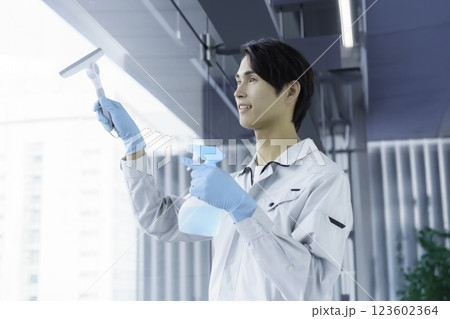 窓ガラスを掃除する若い男性清掃員 撮影協力:スカパー東京メディアセンター 窓ガラスを掃除する若い男性清掃員 撮影協力:スカパー東京メディアセンター 123602364