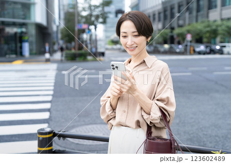 ビル街でスマートフォンを操作している女性 123602489
