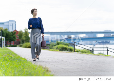 海沿いの道を歩く女性	 123602498