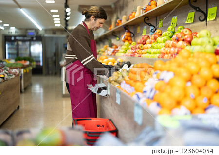 Man shop seller puts pear goods on display case Man shop seller puts pear goods on display case 123604054