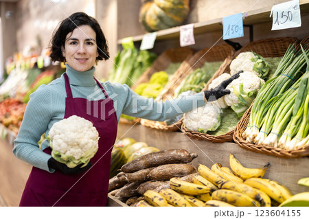 Adult woman seller puts cauliflower on display 123604155