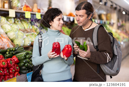 Couple chooses cucumbers and red peppers 123604191