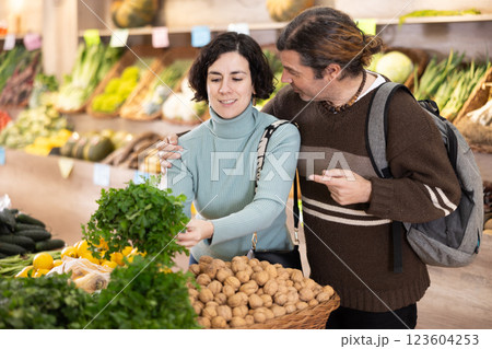 Married couple selects fresh parsley from supermarket counter 123604253