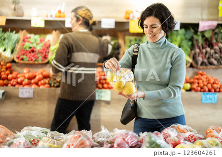 Adult woman choosing apples in plastic bag Adult woman choosing apples in plastic bag 123604261