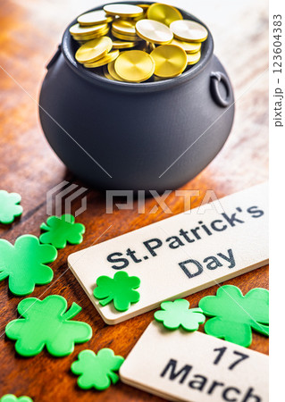 St. Patrick's Day. Green clover leaves decoration and cauldron with golden coins on wooden table. 123604383