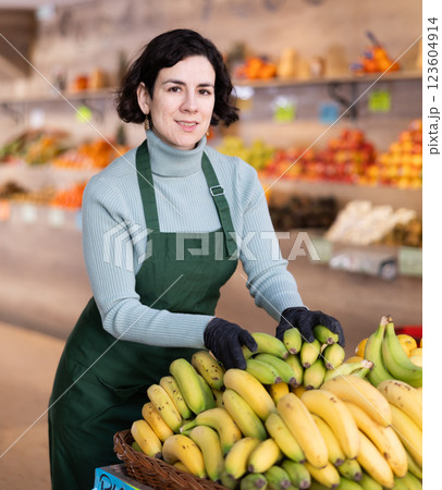 Adult woman seller puts bananas on display 123604914