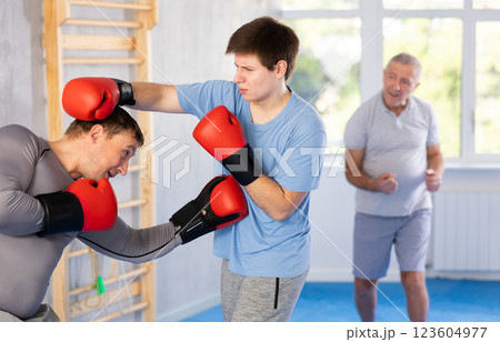 Guy getting hit to torso from sparring partner at boxing training 123604977
