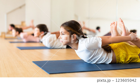 Girl practicing yoga at studio with family 123605042