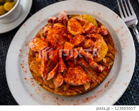 Chopped spicy boiled octopus tentacles with potato slices traditionally seasoned with aromatic paprika 123605057
