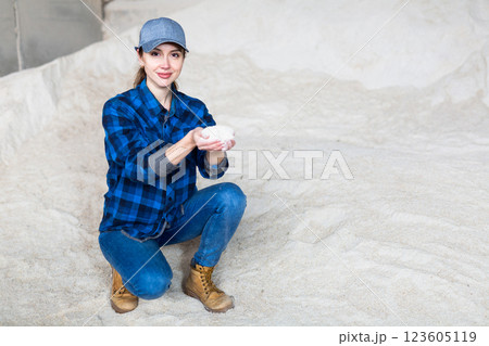 Female farmer holding handful of soy flour in warehouse of livestock farm 123605119