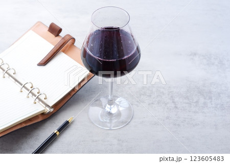 赤ワインを飲みながら、リング式のシステム手帳に日記をつけているイメージ写真 赤ワインを飲みながら、リング式のシステム手帳に日記をつけているイメージ写真 123605483