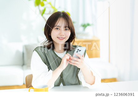 部屋でスマホを操作する若い女性 部屋でスマホを操作する若い女性 123606391
