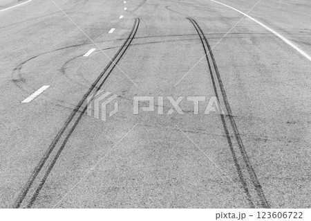 Black tire marks on asphalt road race track, Car tire track asphalt road texture and background, Abstract asphalt road background of tires tracks, Black tyre mark on asphalt road. 123606722