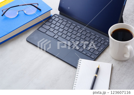 コーヒーを飲みながら、キーボードを接続したタブレット端末で、デスクワークをしているイメージ コーヒーを飲みながら、キーボードを接続したタブレット端末で、デスクワークをしているイメージ 123607116