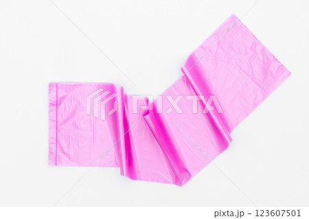 Roll of pink plastic garbage bags on white background, Pink color garbage bags roll,  Roll of pink plastic garbage bags on white background. 123607501