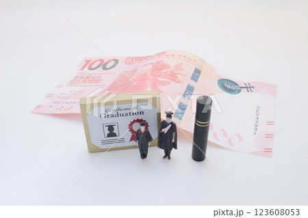 Graduation Concept with Diploma, Money, and Miniature Graduate Figurine Graduation Concept with Diploma, Money, and Miniature Graduate Figurine 123608053