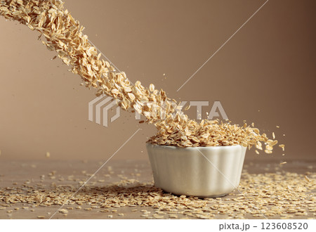 Oat flakes in motion on a beige background. Oat flakes in motion on a beige background. 123608520