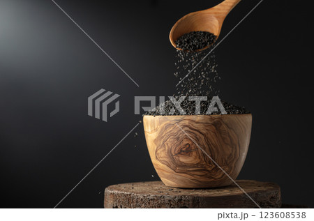Black sesame is poured in wooden bowl. Black sesame is poured in wooden bowl. 123608538