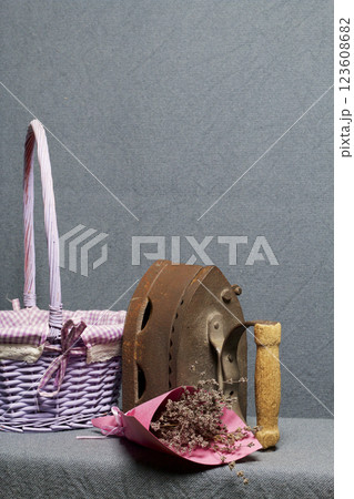 Old iron, heated by hot coals. Located near a wicker baskets. Near a bouquet of dried flowers. Old iron, heated by hot coals. Located near a wicker baskets. Near a bouquet of dried flowers. 123608682
