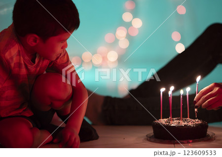 Child watching lighting birthday cake candles with bokeh effect Child watching lighting birthday cake candles with bokeh effect 123609533
