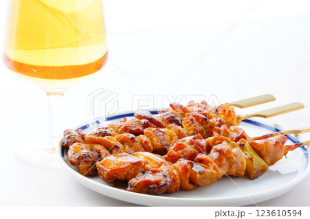 焼き鳥（タレ）の盛り合わせと、ビールのグラス 123610594