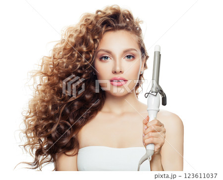 Isolated brunette model using curling iron on white background. Isolated brunette model using curling iron on white background. 123611037