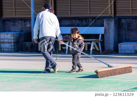 テニスコートを整備する親子　ブラシ掛け 123611329