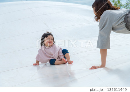 【巨大な遊具でお座りする乳幼児とママ】 【巨大な遊具でお座りする乳幼児とママ】 123611449