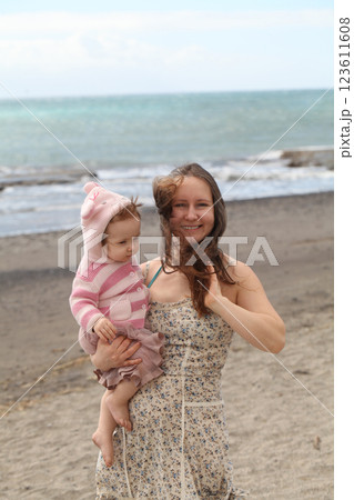 Joyful young mother and daughter baby girl. Young woman and child one year old 123611608