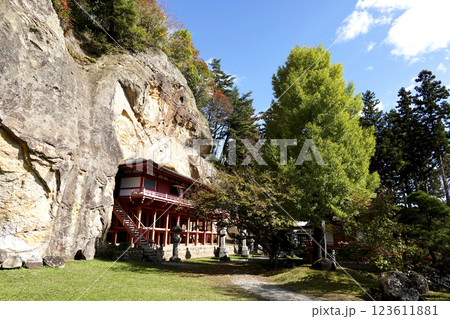 崖下の岩屋に建つ達谷窟毘沙門堂と崖上の紅葉 123611881