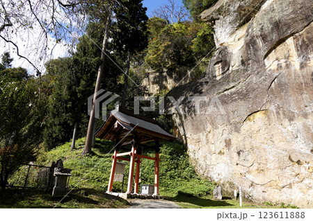 岸壁に顔だけが残った岩面大仏（顔面大仏）とその正面にある本坪鈴、さい銭箱がある礼堂 123611888