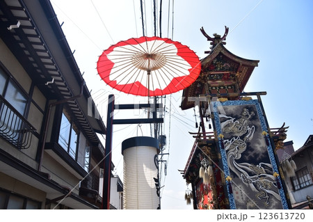 日本の岐阜県の高山市　春の高山祭　巡行する屋台と装飾品の豪華な掛軸　道路に掲げられた和傘と提灯 123613720