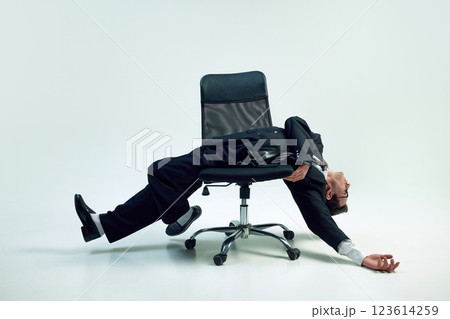 Entrepreneur reclining and illustrating psychological challenges of modern business through pose against white background. Mental fatigue. Entrepreneur reclining and illustrating psychological challenges of modern business through pose against white background. Mental fatigue. 123614259