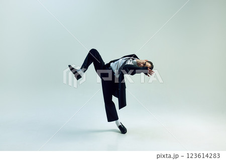 Young businessman bending sideways with lifted leg and covered face against white studio background. Concept of business, psychology, pressure Young businessman bending sideways with lifted leg and covered face against white studio background. Concept of business, psychology, pressure 123614283