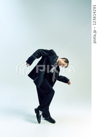 Businessman bending forward, arms loosely hanging, head tilted in deep thought against white studio background. Concept of business, mental fatigue 123614291