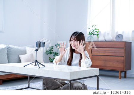 笑顔で動画撮影をする若い女性 笑顔で動画撮影をする若い女性 123614316