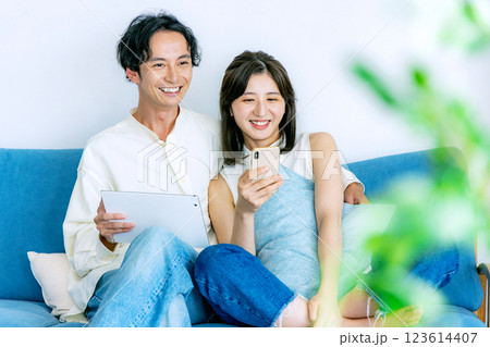タブレットとスマホを見るカップル 123614407