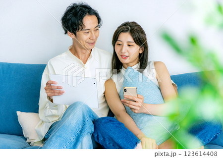 タブレットとスマホを見るカップル 123614408