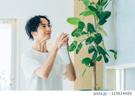 観葉植物に水をあげる男性 123614489